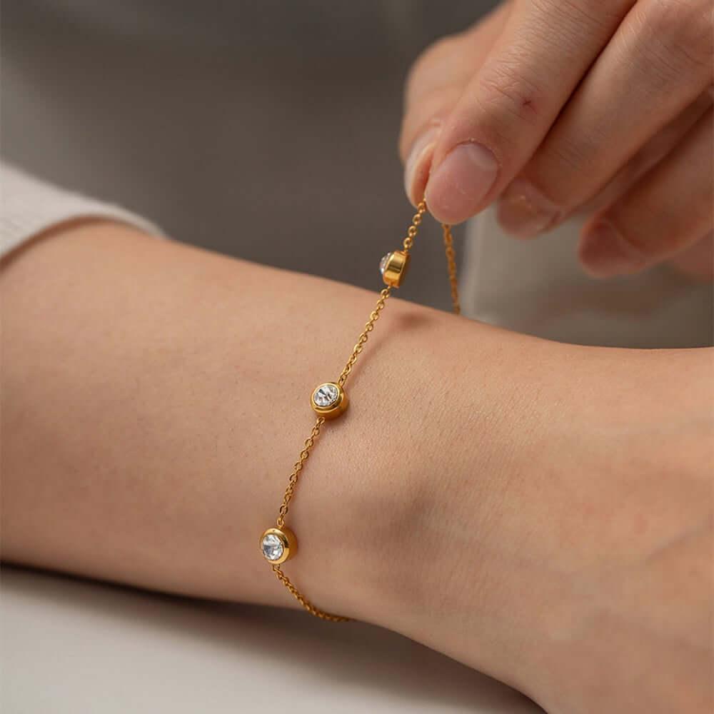 Elegant gold zircon bracelet with sparkling stones worn on a wrist.
