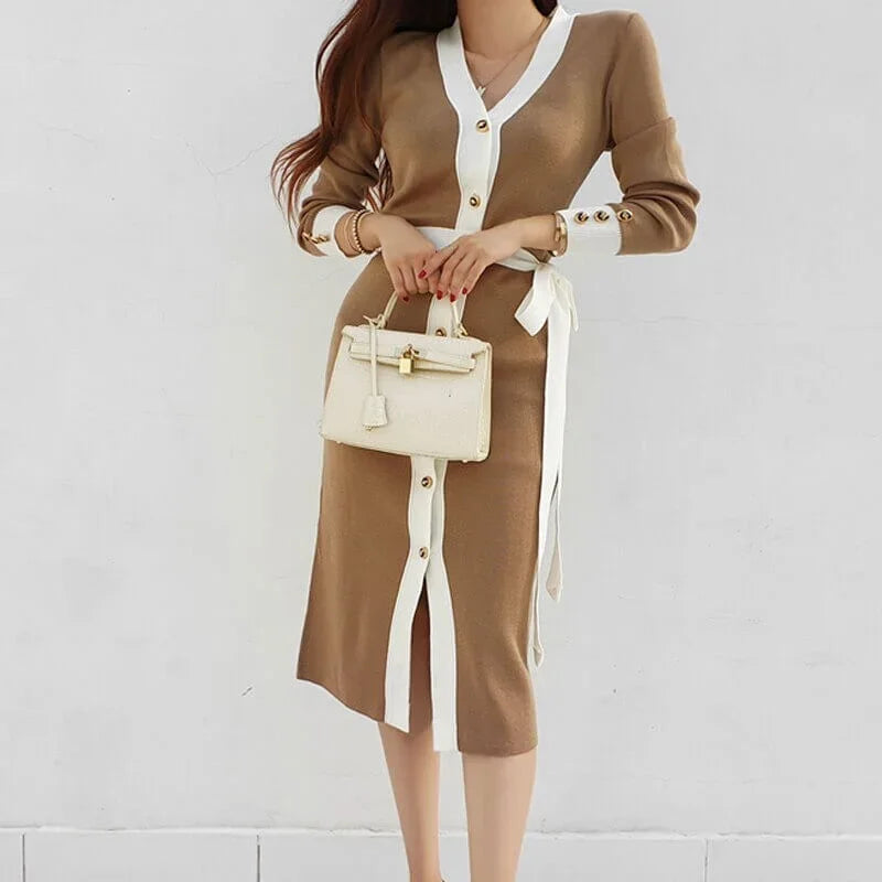 Woman wearing a Lunara brown knitted midi dress with white trim and buttons.
